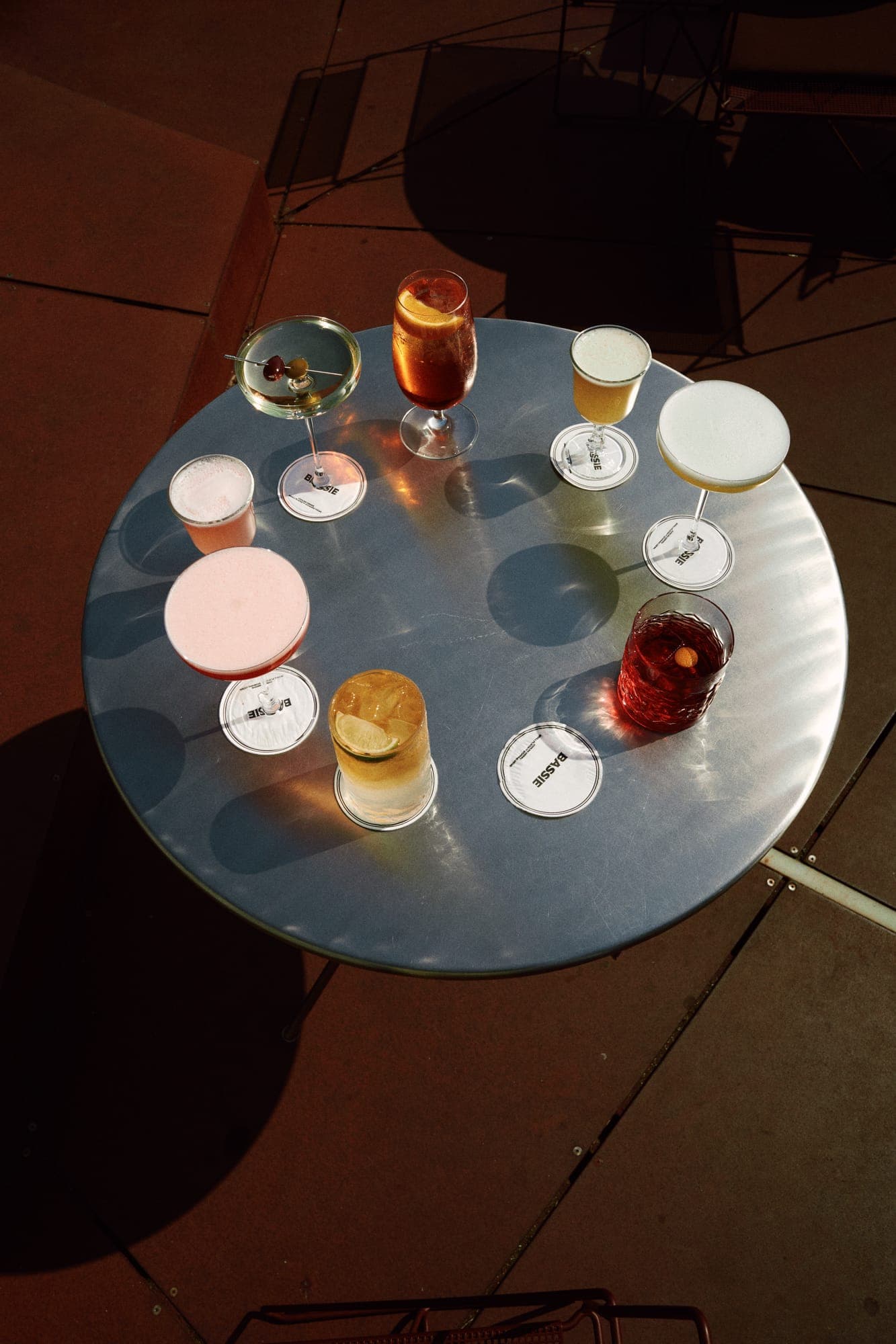 Overhead of a round table full of cocktails and bites