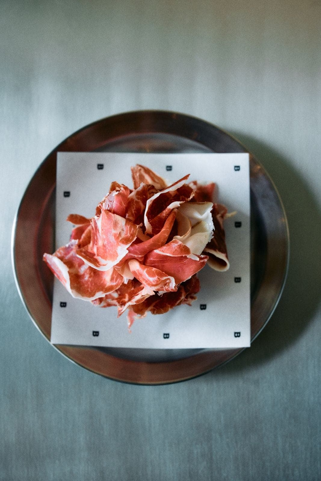 Sliced Ibérico charcuterie on Bassie-branded paper