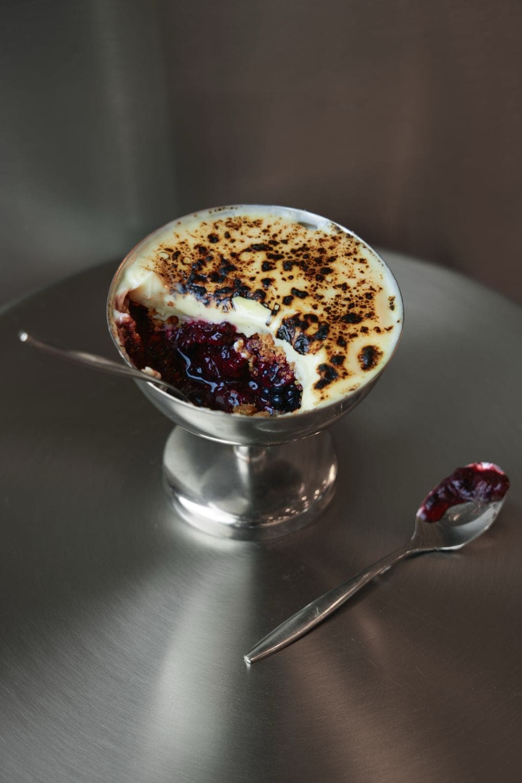 Crème brûlée with berries in a silver coupe
